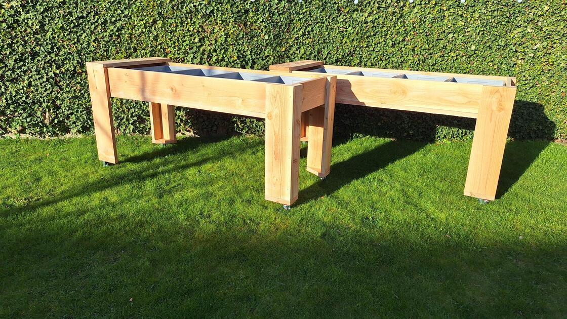 Verrijdbare houten kweektafel met plantenbak op wielen in de tuin